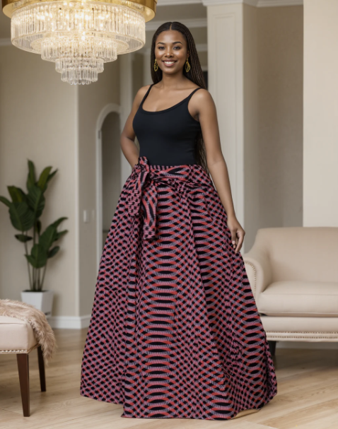 Woman in a black top and red patterned skirt standing in a living room with a chandelier and couch.