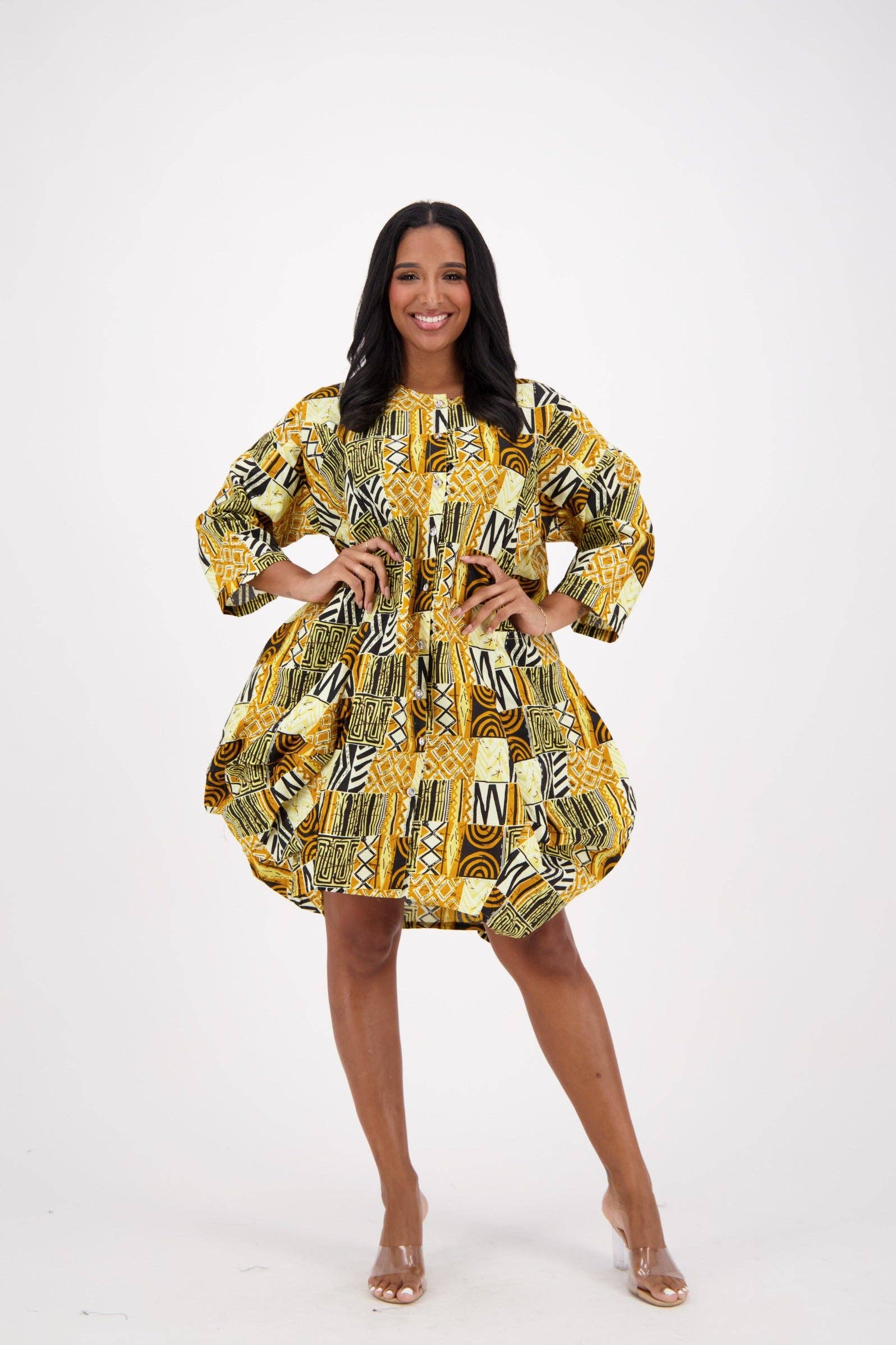 Woman wearing a yellow and black patterned dress on a white background
