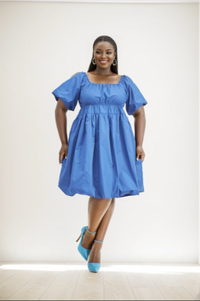 Woman wearing a blue dress with puffed sleeves on a white background