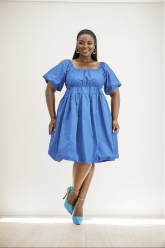 Woman wearing a blue dress with puffed sleeves on a white background