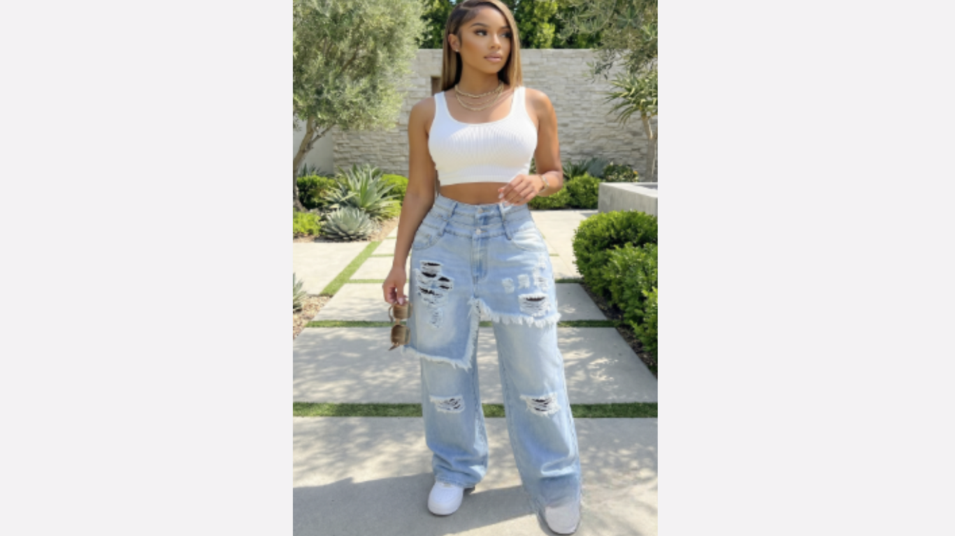 Woman wearing a white crop top and light blue jeans standing outdoors.