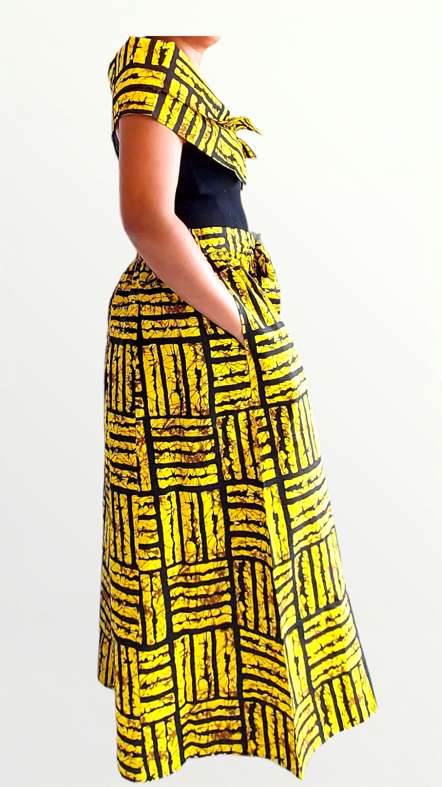 Person wearing a yellow and black patterned skirt on a white background