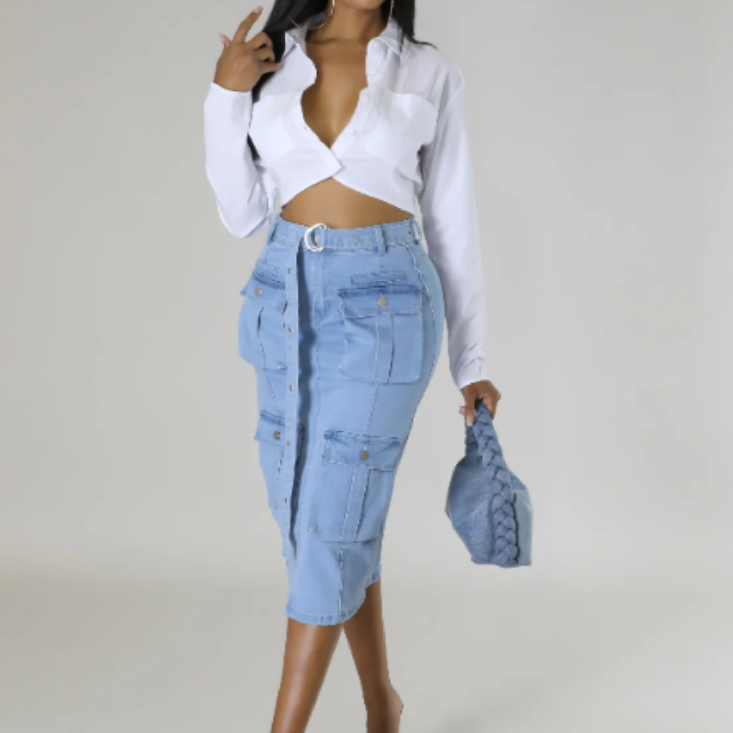 Person wearing a white blouse and light blue denim skirt against a plain background
